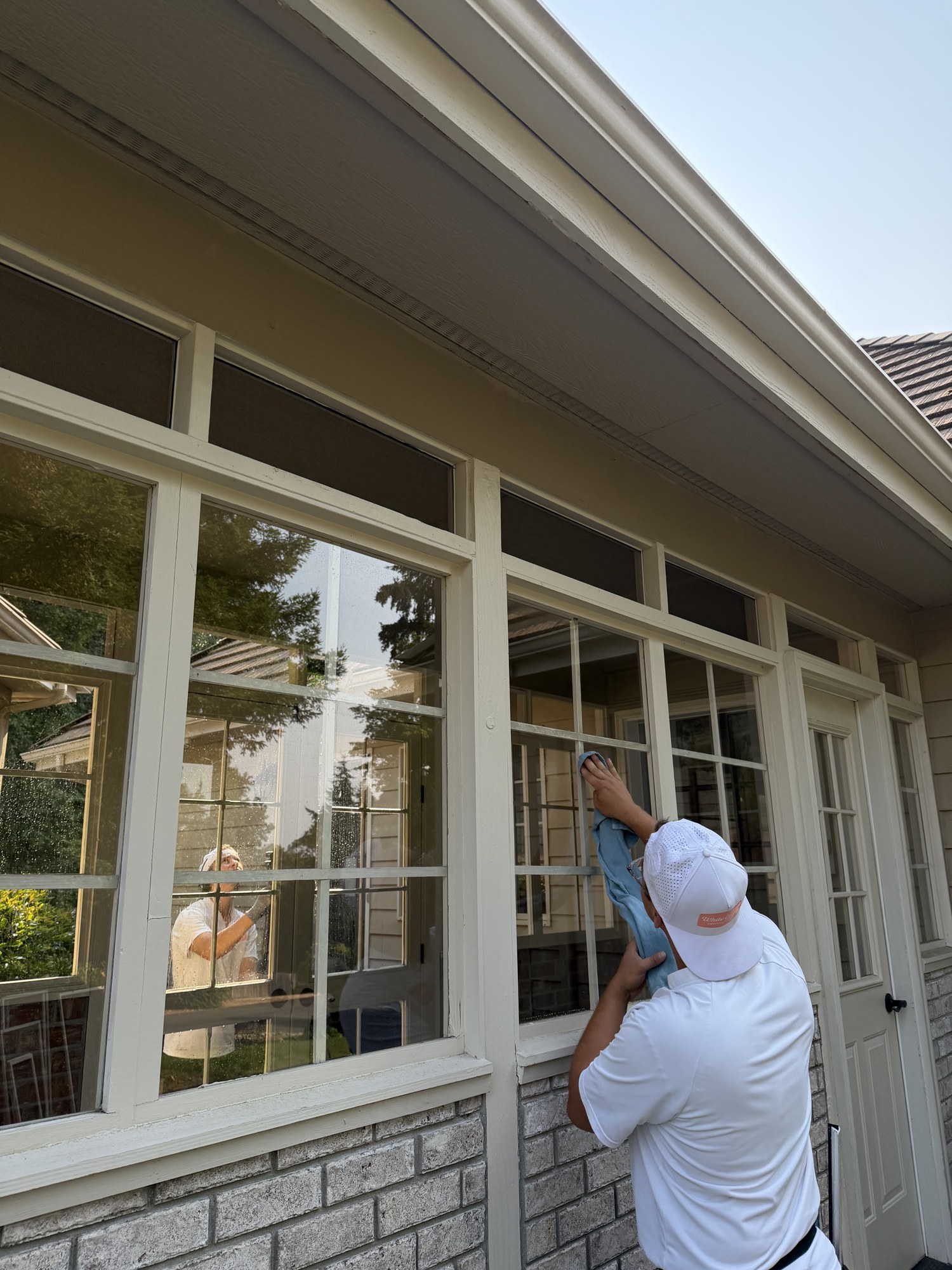 Hand detailing divided-pane windows at a home