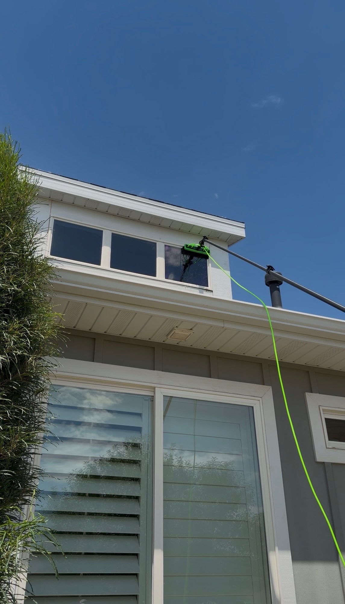 Water-fed pole cleaning an upper-story window